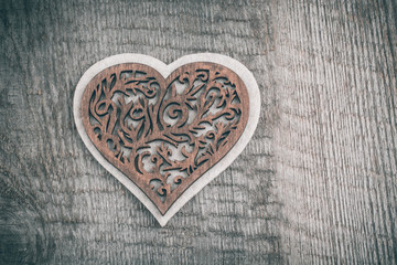 Fototapeta premium Valentines day wooden carved heart over wooden table background with copy space.