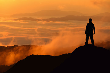 Silhouette of man standing on the top of mountain