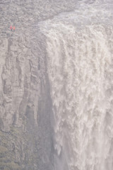 Obraz premium Vertical view of famous Dettifoss waterfall with two small people, Iceland.