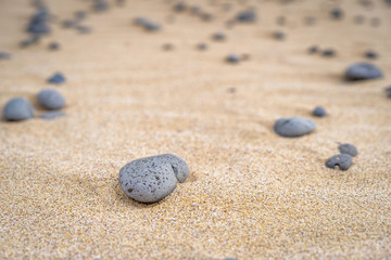 Fototapeta na wymiar Macro view of grey stone in yellow sand.