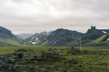 Typical Icelandic volcanic highland landscape with Iceland flag.
