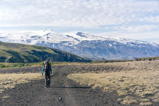 Female hiker walking Laugavegur trail in front of  Eyjafjallaj&ouml;kull volcano.