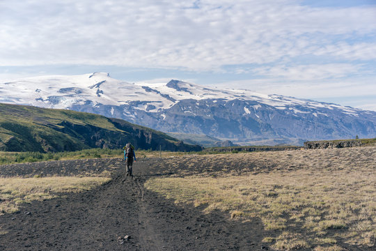 Female hiker walking Laugavegur trail in front of  Eyjafjallaj&ouml;kull volcano.
