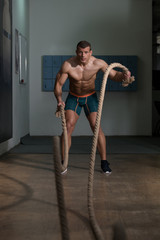 Young Man Battling Ropes At Gym Workout Exercise