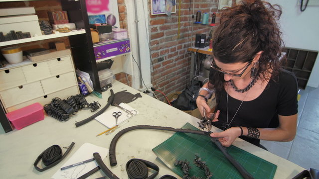 Young eco jewelry maker creating fashion accessories in her atelier
