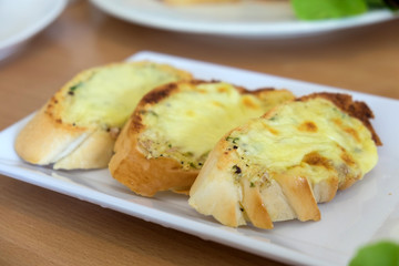 Close-up of a dish of garlic bread with cheese