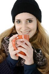 Frau mit Mütze, Schal und Pullover als Kleidung für Winter und Kälte trinkt Kaffee oder Glühwein