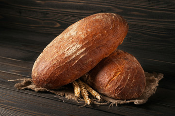two loaves of bread on a dark wooden background