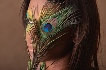 Studio portrait of pretty glamour girl with brazilian peacock makeup