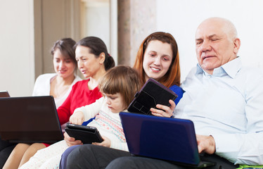  family  with laptops on sofa at home