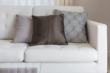 modern white sofa with brown pillows