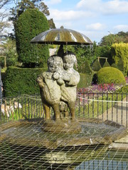Statue fountain of little girl and boy with a puppy and an umbrella at Sewerby Park, Bridlington, East Yorkshire UK