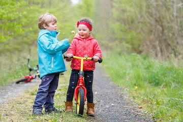 Little girl and boy playing together in forest