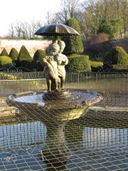 Statue fountain of little girl and boy with a puppy and an umbrella at Sewerby Park, Bridlington, East Yorkshire UK