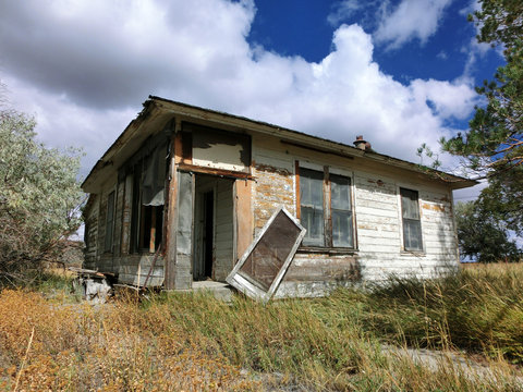Abandoned prairie shack with broken windows and door - landscape photo
