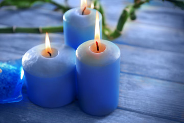 Fototapeta na wymiar Blue candles with spa salt and bamboo on table