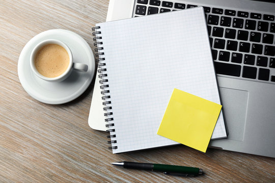 Empty Yellow Adhesive Paper, Notebook On Laptop Keyboard, Pen And Coffee Cup On Desk Background