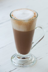 coffee with pattern in a white cup on wooden background