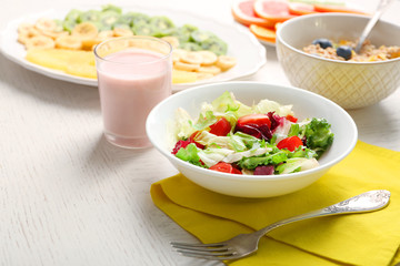 Tasty oatmeal and vegetable salad on wooden background. Healthy eating concept.