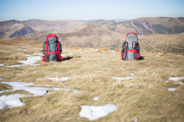 Red backpack standing on top of the mountain.