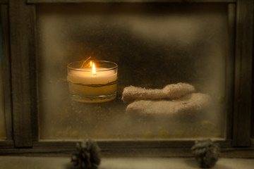 Winter window. Cozy room. Candlesticks on a windowsill. Wool socks.