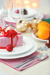 Christmas table setting with holiday decorations on fireplace background