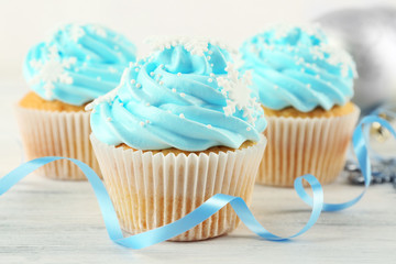 Few tasty blue cupcakes with decorations on light background