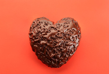 Chocolate heart on a red background, close up