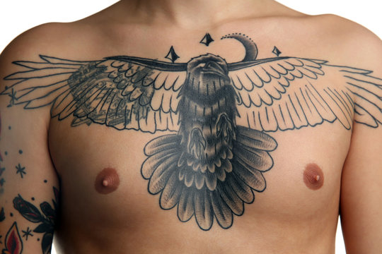 Bird tattoo on male chest over white background