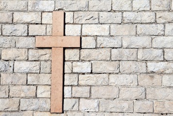 cross carved on marble attached to the stone wall