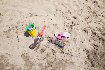 zapatillas y juguete de playa