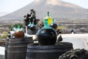 Gordijnen Barrels and  big bottles with grape wine - malvasia.  Lanzarote, Spain © wjarek