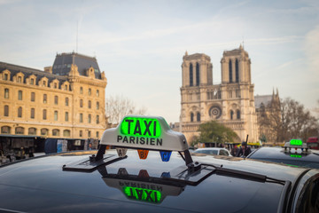 Parisien taxi with Notre Dame cathedral - obrazy, fototapety, plakaty