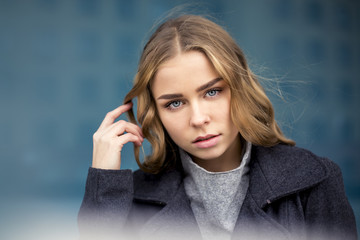 serious blonde with long hair in the city walks