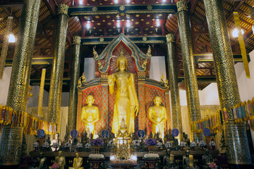 Golden standing Buddha in Viharn of  Wat Suan Dok temple.