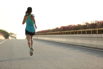 young fitness woman runner running on seaside bridge