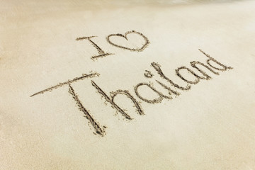 Fototapeta na wymiar letters written on sand i love heart Thailand