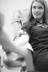 Female patient waiting for blood taking procedure in a chair