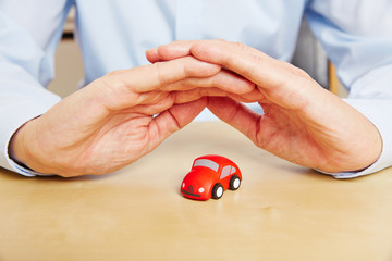 Autoversicherung mit Händen über Auto