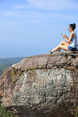 young woman backpacker use digital tablet on mountain peak