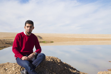 Naklejka na ściany i meble Iraqi brunette man in winter season standing near lake
