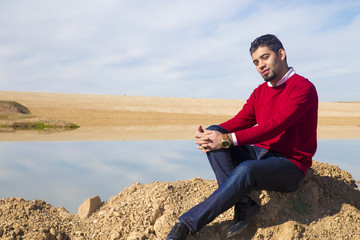 Fototapeta na wymiar Iraqi brunette man in winter season standing near lake