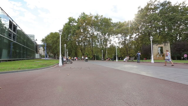 Many people having rest, tourists taking pictures of sculptures in summer park