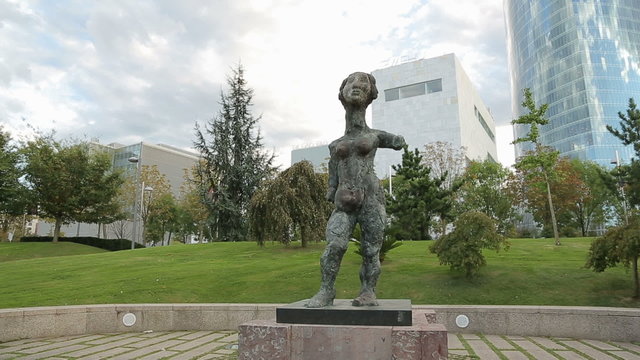 Strange female statue exhibited in the park in front of modern business center