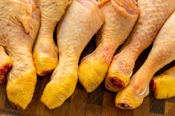 Fusi di pollo crude sul tagliere di legno