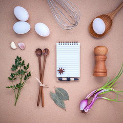 Fototapeta na wymiar Four white eggs with note book ,pepper bottle ,wooden spoons ,ba
