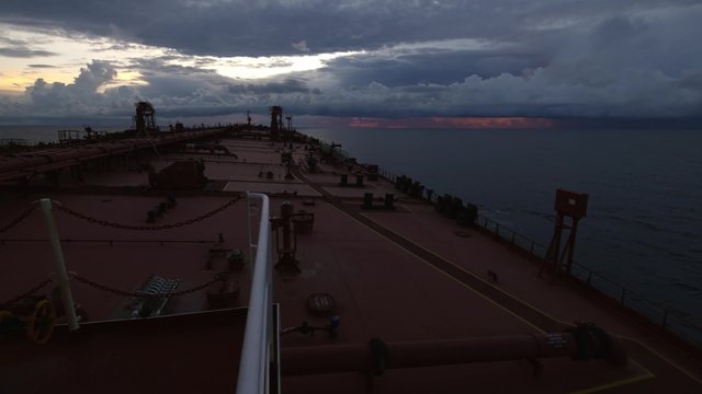 Tanker ship sails to sunset