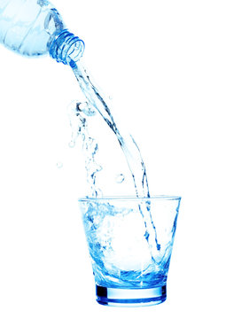 Pouring water on a glass on white background