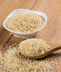 sesame seeds with wooden spoon on white background