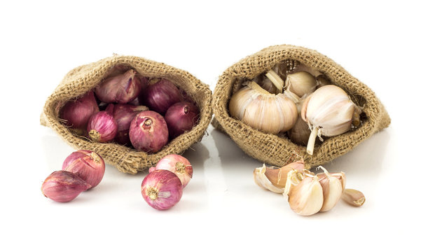 Closeup of garlic and shallot in brown bag
